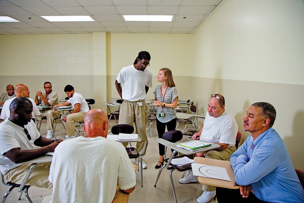 Kyle Campbell takes a break before his “Globalization” class to confer with Kaiya Letherer, assistant director of the Prison Bridge Program. Letherer, a College Unbound graduate herself, is nominally the class instructor, but she sees herself more as a facilitator, guiding the incarcerated students through what she calls “the process of self-transformation.”