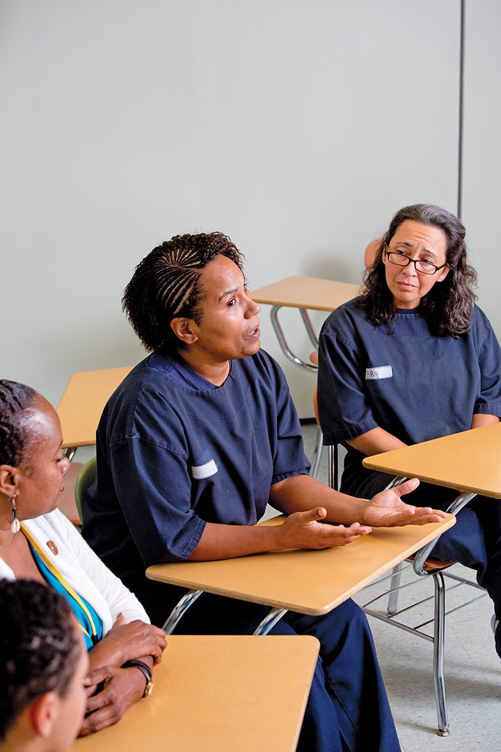 As Kimberly Fry (right) listens attentively, Penny Juan makes a point during a Prison Bridge Program class held in the Rhode Island women’s unit.