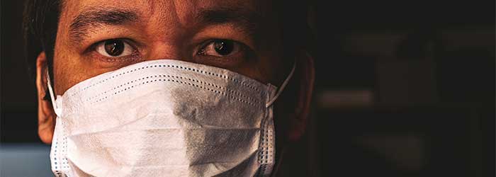 Close up of Black doctor's face mostly covered by a COVID mask.