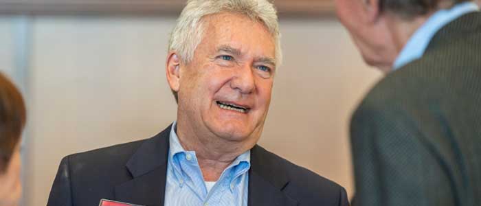 Photo of Paul Helmke smiling and conversing with a colleague. 