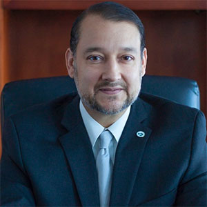 William Serrata seated at an executive desk.