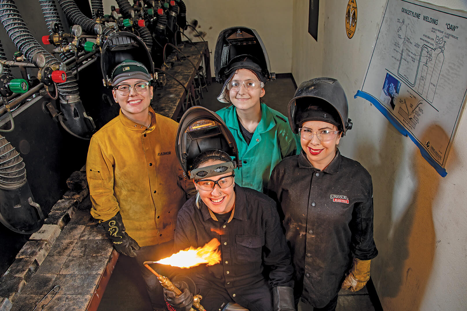 Group of people hanging around a blowtorch for a photo op.